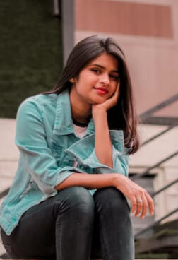 Picture-of-a-girl-sitting-with-her-chin-in-hand-on-a-bench-indoors-Photographed-by-Anshika-Panchal